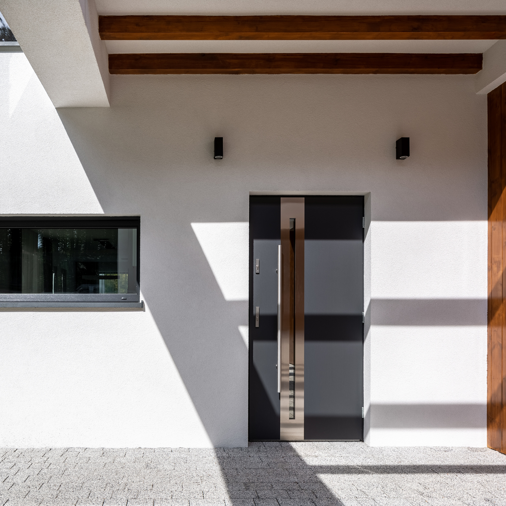 Close-up on modern front door in house with white and wooden facade