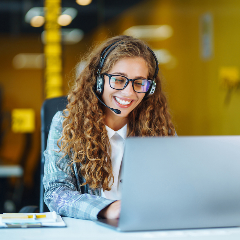 Call center agent with headset working on support hotline in modern office. Video conference.  Оnline training.